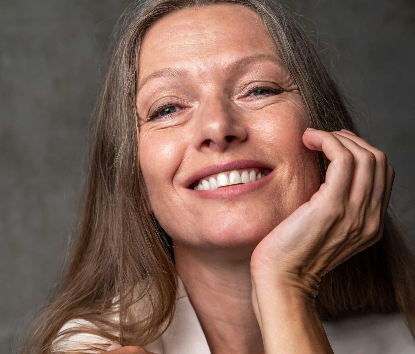 Woman smiling with a hand to her chin