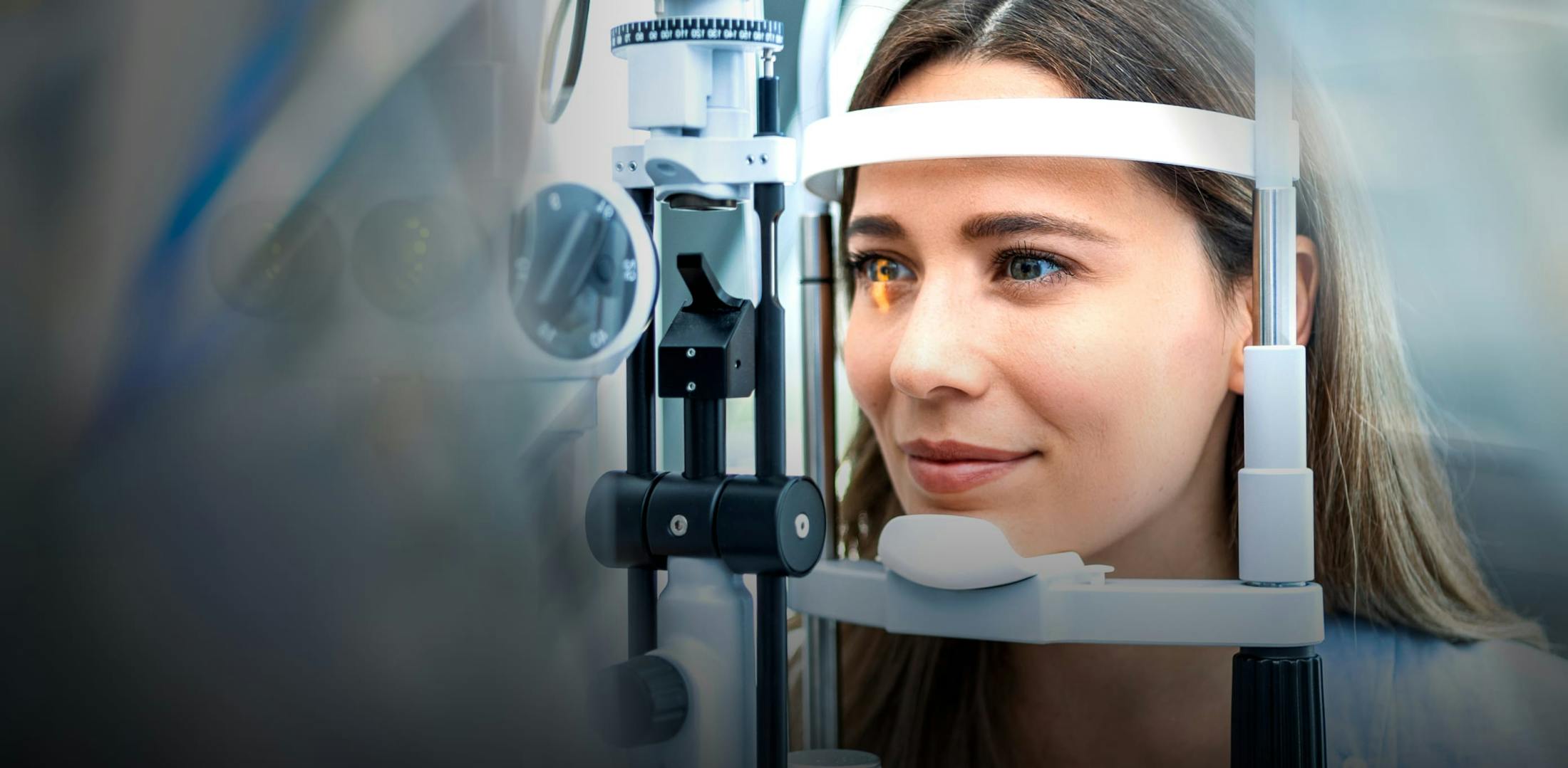 A woman looking into an eye testing machine