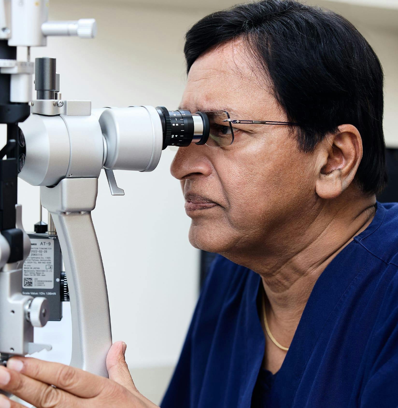 Doctor looking into eye exam equipment