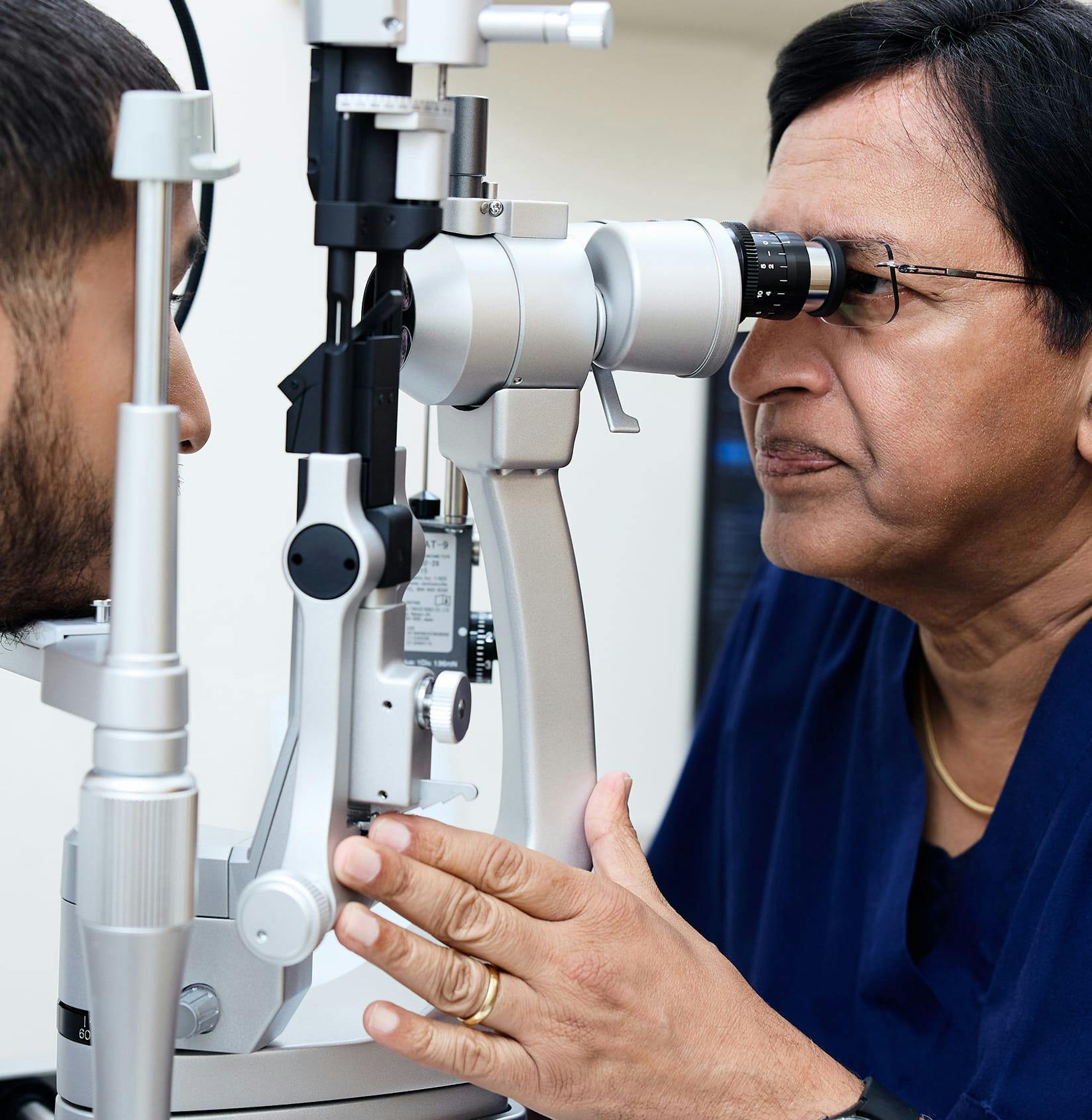 Doctor looking into eye equipment