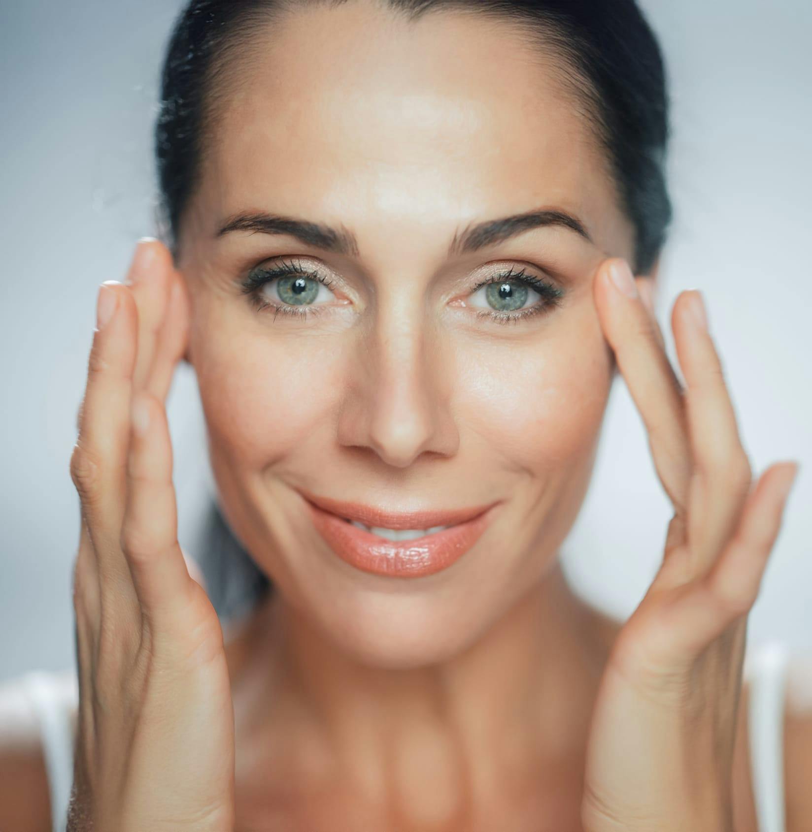 Woman smiling touching eyes