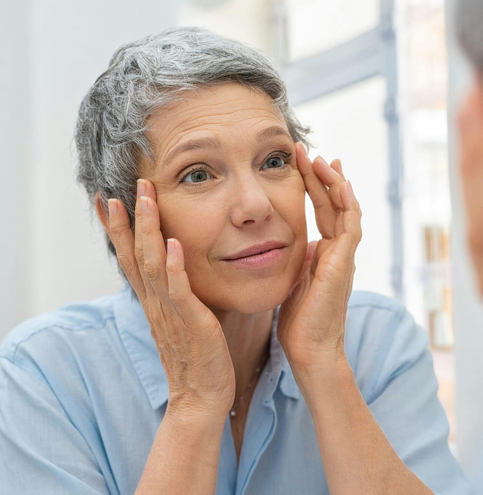 Woman looking at eyes in mirror