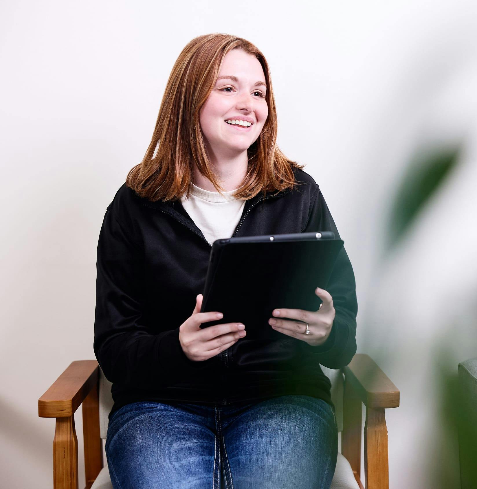 woman smiling holding clipboard