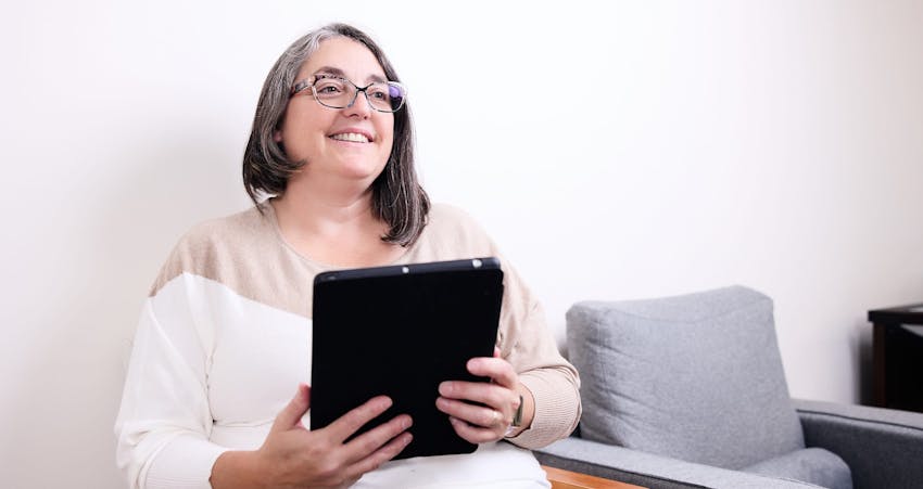 Woman smiling holding clipboard