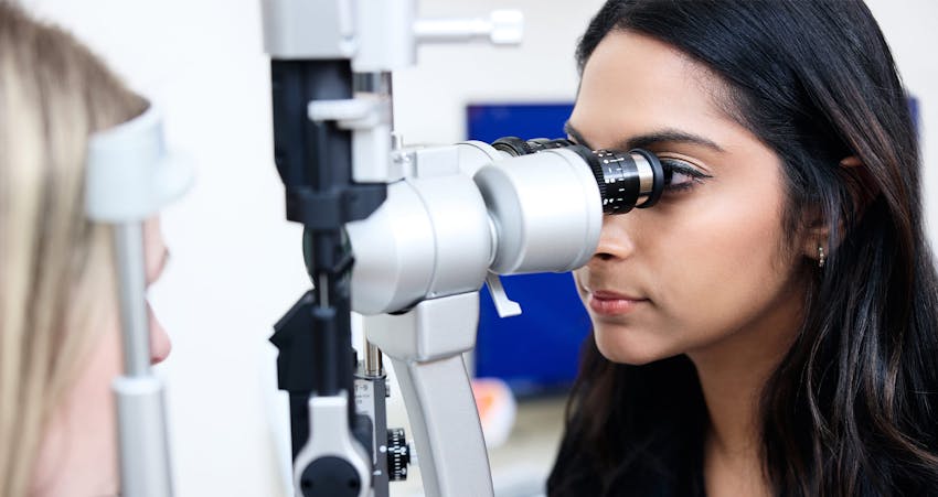 Doctor looking into eye exam equipment