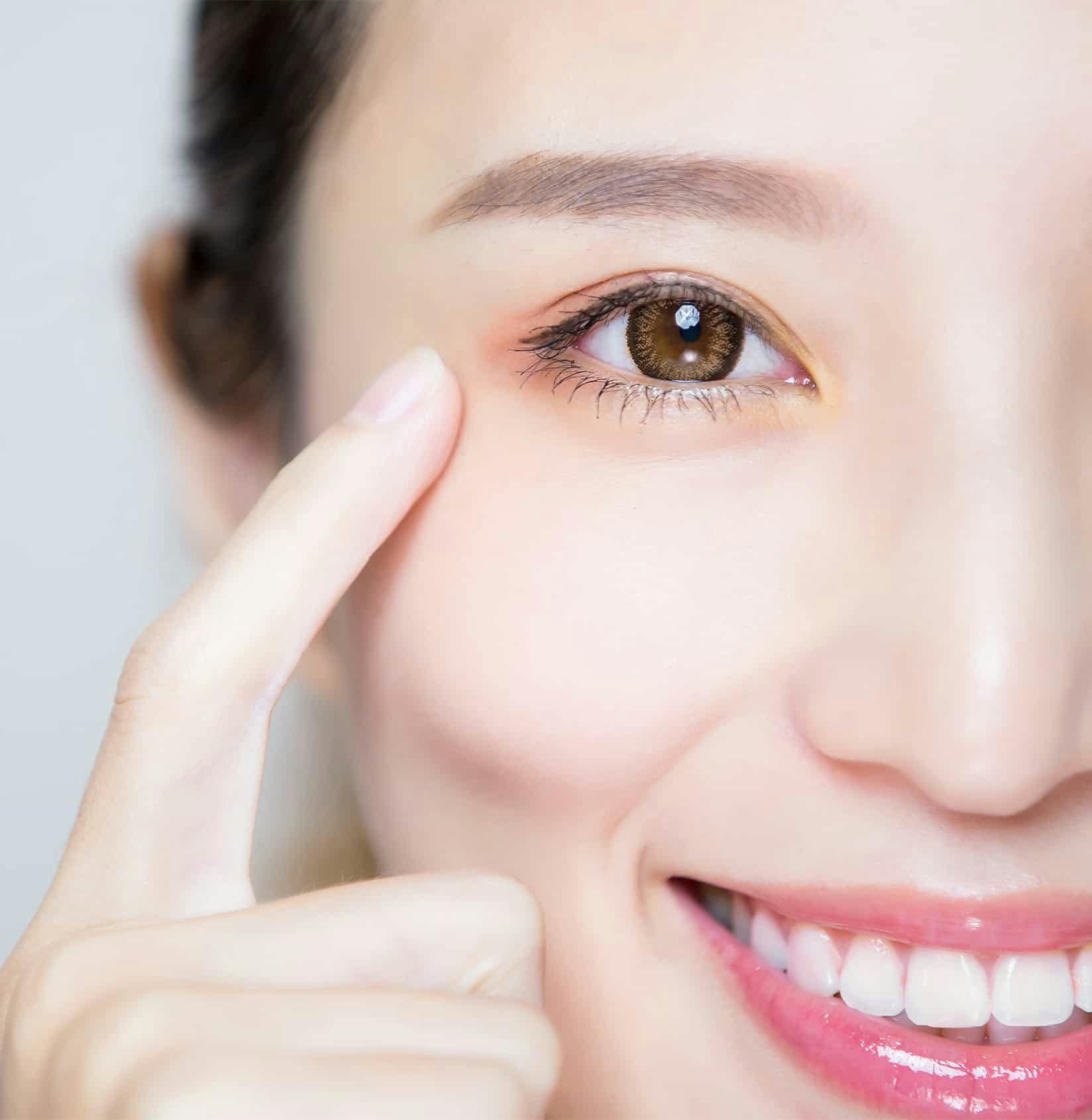close up of woman pointing to eye