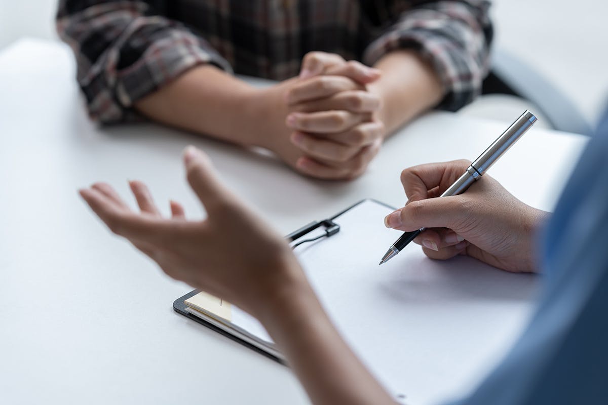 A patient completing a questionnaire with a healthcare practitioner