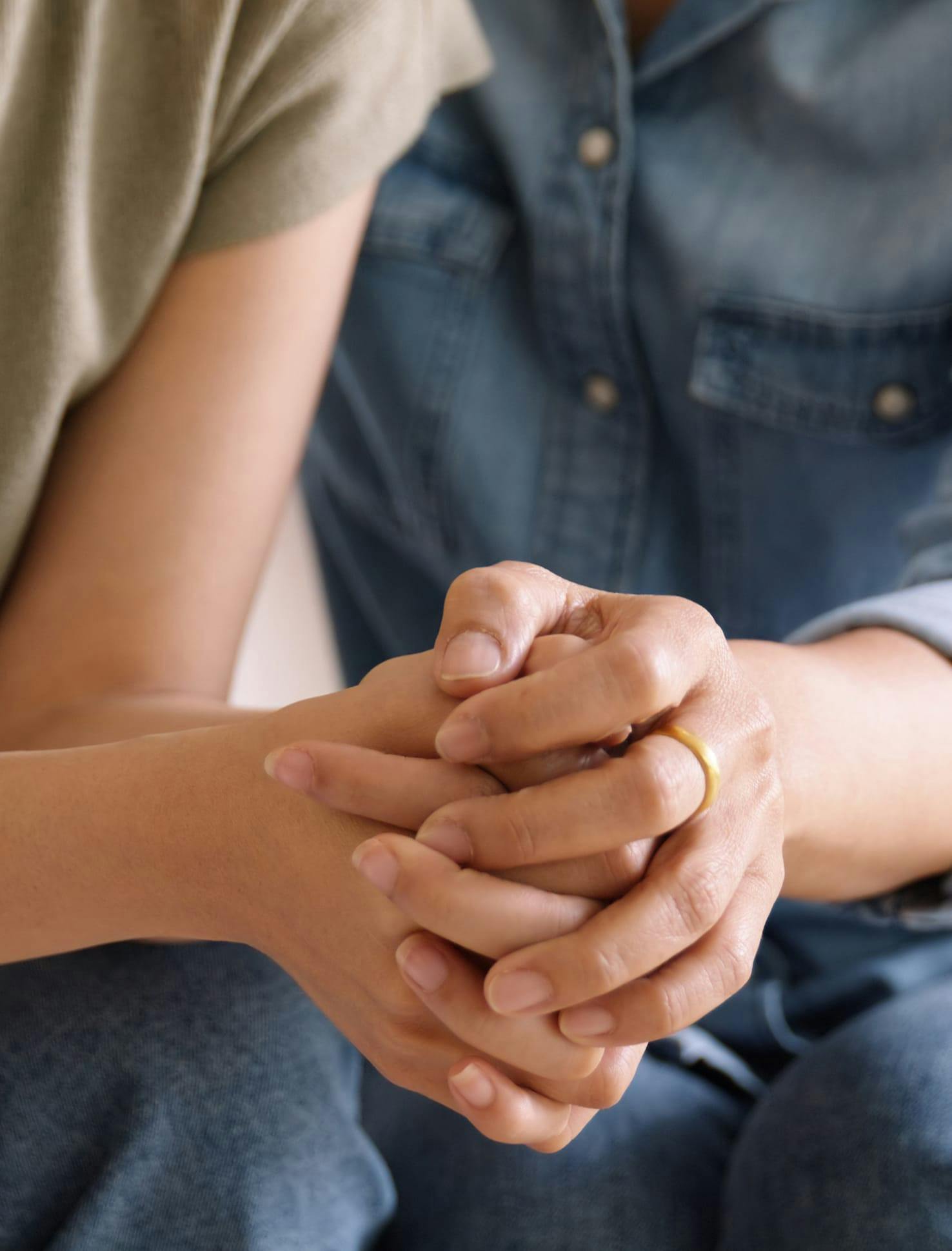 Couple holding hands in sorrow