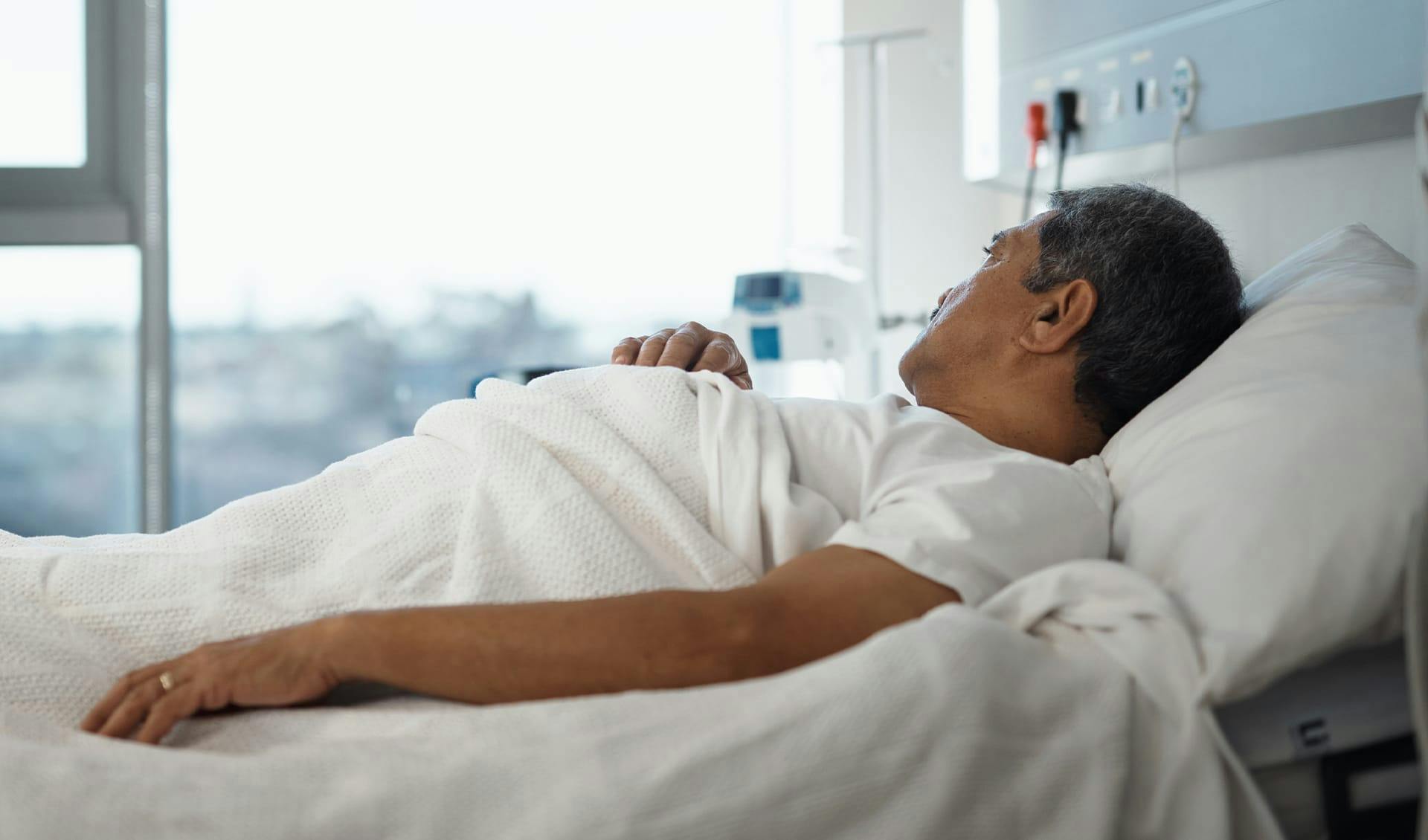 Man in hospital bed looking out window