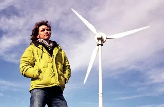 Dale Vince next to a windmill