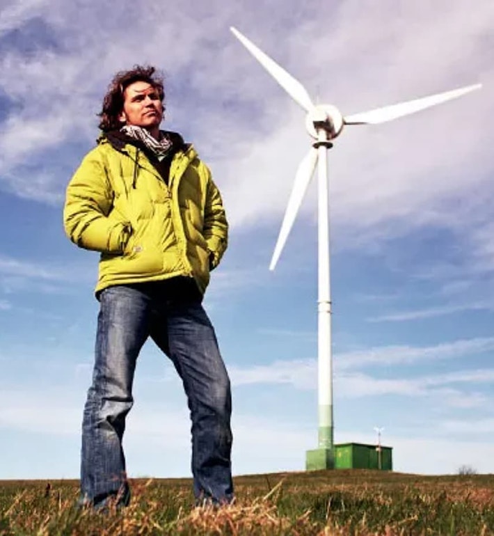 Dale Vince next to a windmill