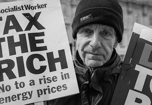 Protestor with 'tax the rich' sign