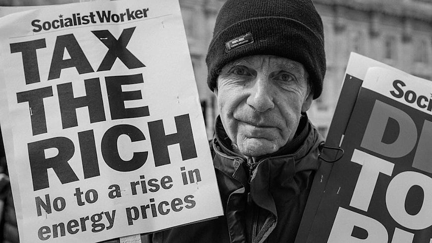 Protestor with 'tax the rich' sign