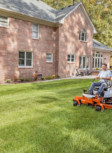 RZ 261 in yard Man using STIHL zero turn mower in backyard