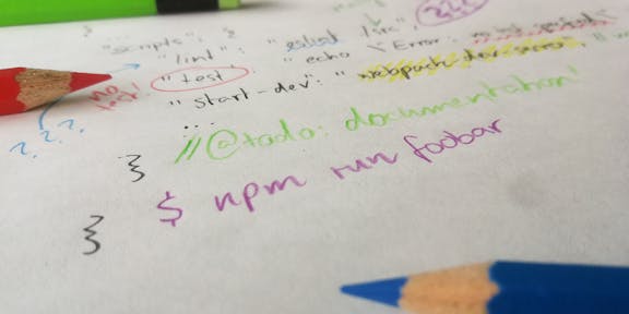 piece of paper with two pencils and some handwritten lines of code