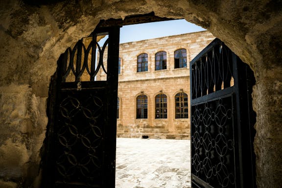 A castle-like building behind a half-open gate