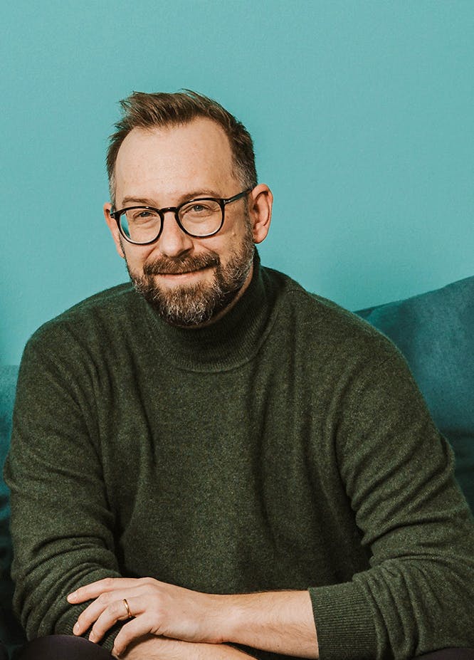 Portrait Portrait of a man wearing glasses and beard in green turtleneck against turquoise background