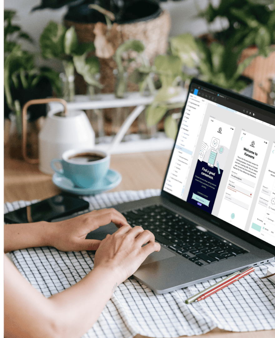 Person arbeitet an einem Laptop mit UI/UX-Design-Oberfläche in grüner und dunkler Farbpalette, neben einer Tasse Kaffee an einem Schreibtisch mit Pflanzen.