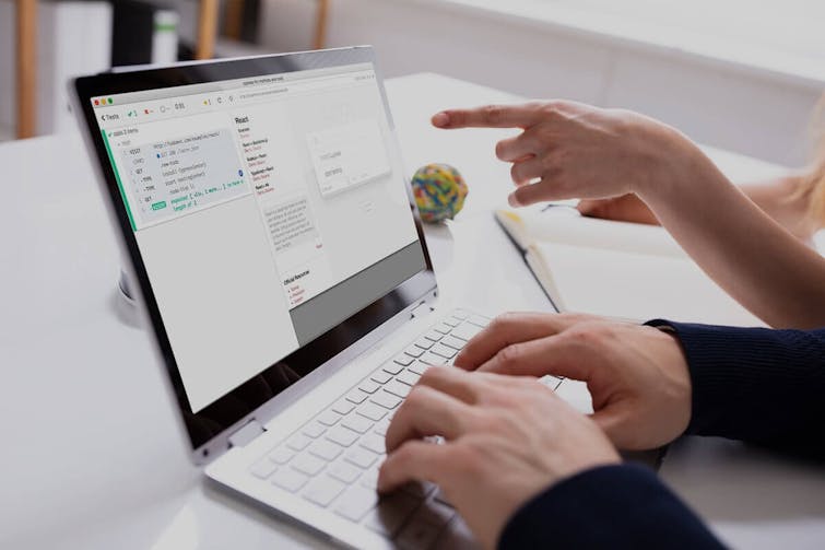 Person arbeitet an einem Laptop mit Web-Design-Interface und Wireframes auf dem Bildschirm