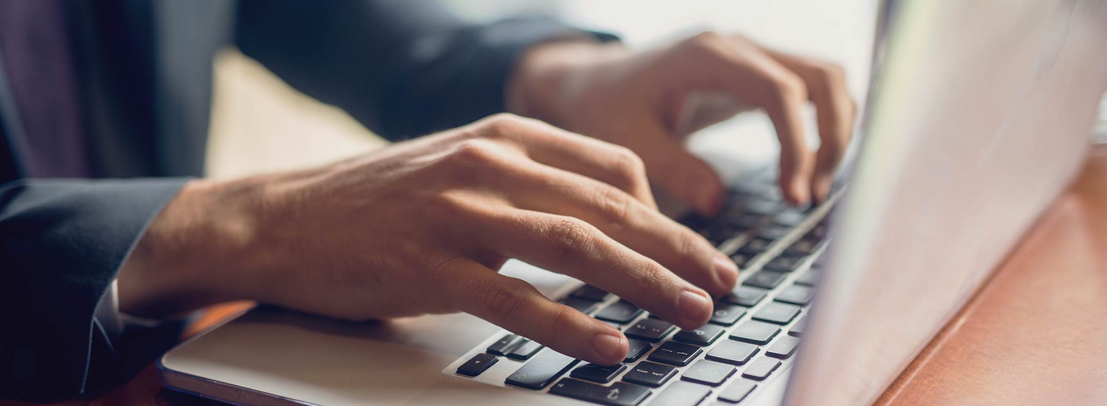 Laptop-Arbeit im Workshop Hände einer Person tippen auf einer Laptop-Tastatur während einer Arbeitssitzung