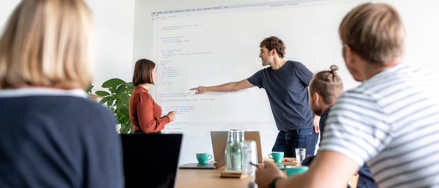 Facilitator presents code on screen during a team workshop session