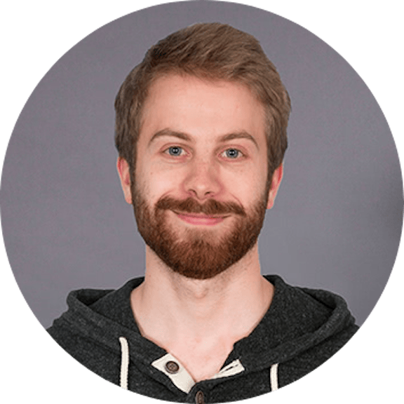 Portrait Photo Portrait of a man with brown hair and beard wearing a black hoodie against a gray background