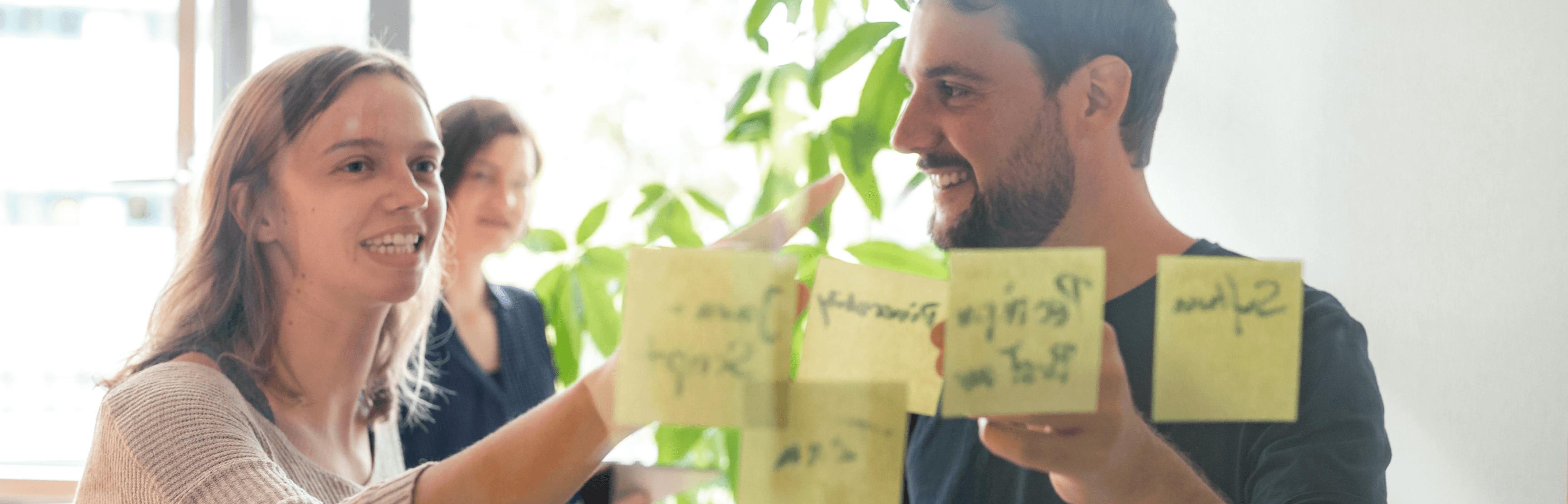 Peerigon Team bei einem UI-Design-Workshop mit Sticky Notes an einer Wand