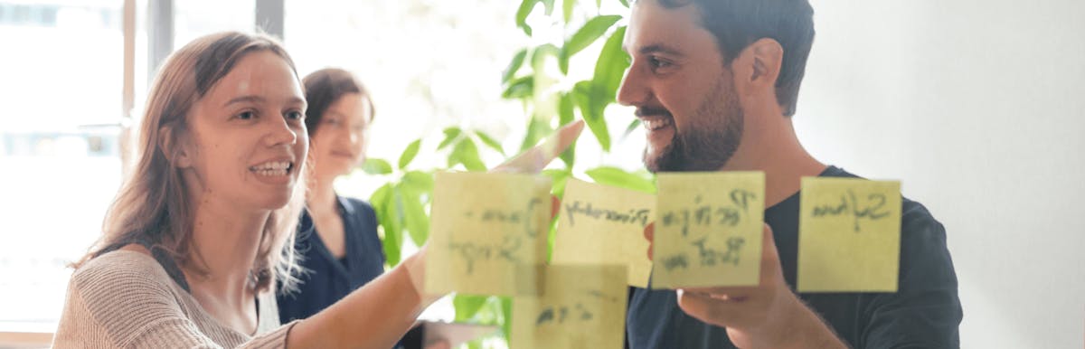 Peerigon Team members collaborating on UI design with sticky notes on a wall during a design sprint workshop
