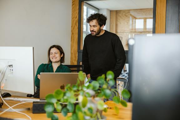 UX/UI und Dev-Teamarbeit im modernen Büro Developer und Designerin arbeiten zusammen an einem Projekt
