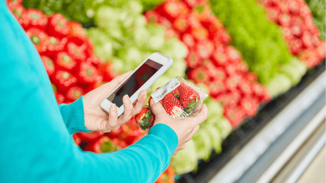 Consumer scanning strawberry package barcode in supermarket.