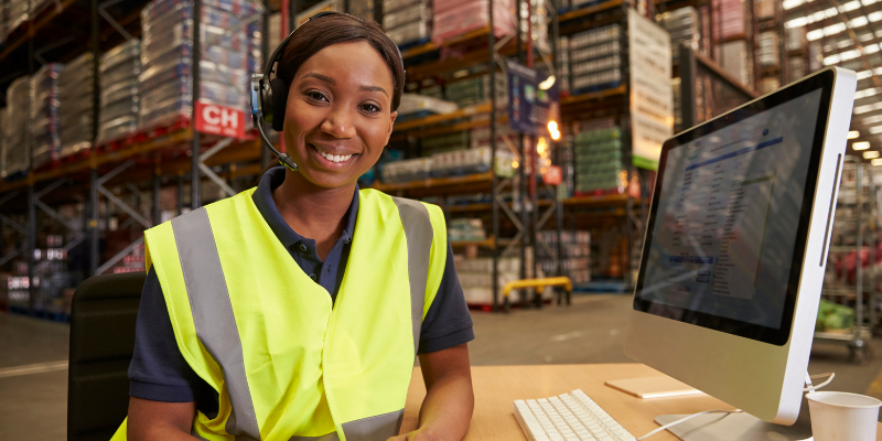 woman smiling in warehouse at desk