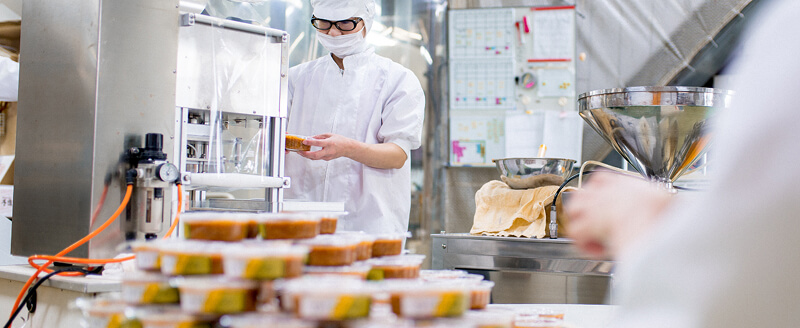 Quality operator checking food packaging in product batch.