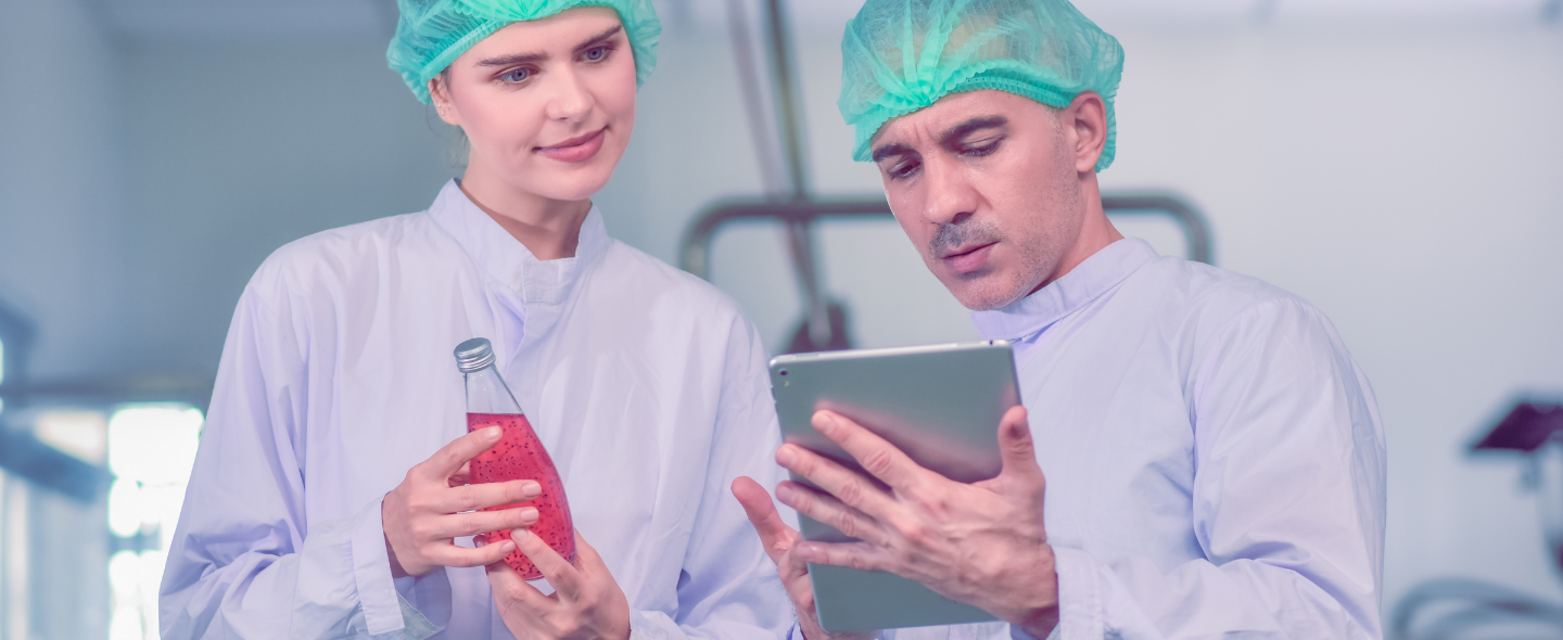 Two quality personnel check product quality and record with a tablet.