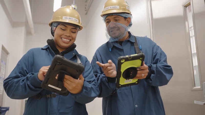 two maunfacturing workers on the plant floor using SafetyChain on tablets