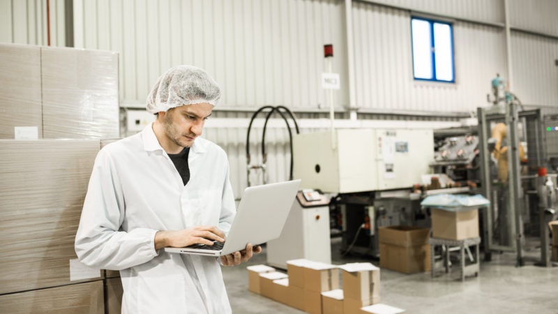 food safety worker on laptop in warehouse