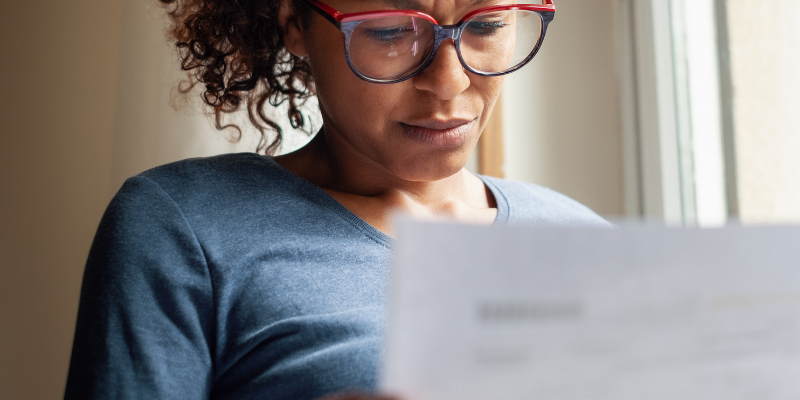woman with glasses reading paperwork