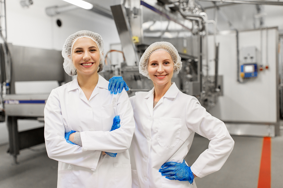 two women on a plant floor in PPE