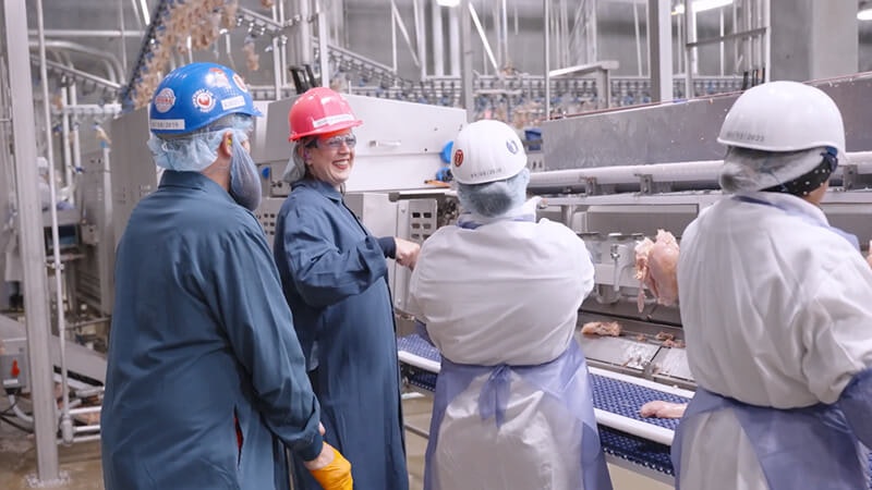 Supervisor fist bumping operator on the manufacturing plant floor