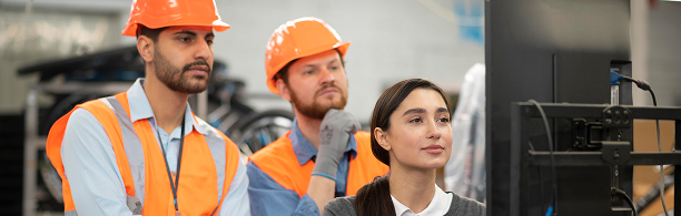factory workers looking at plant data on a screen