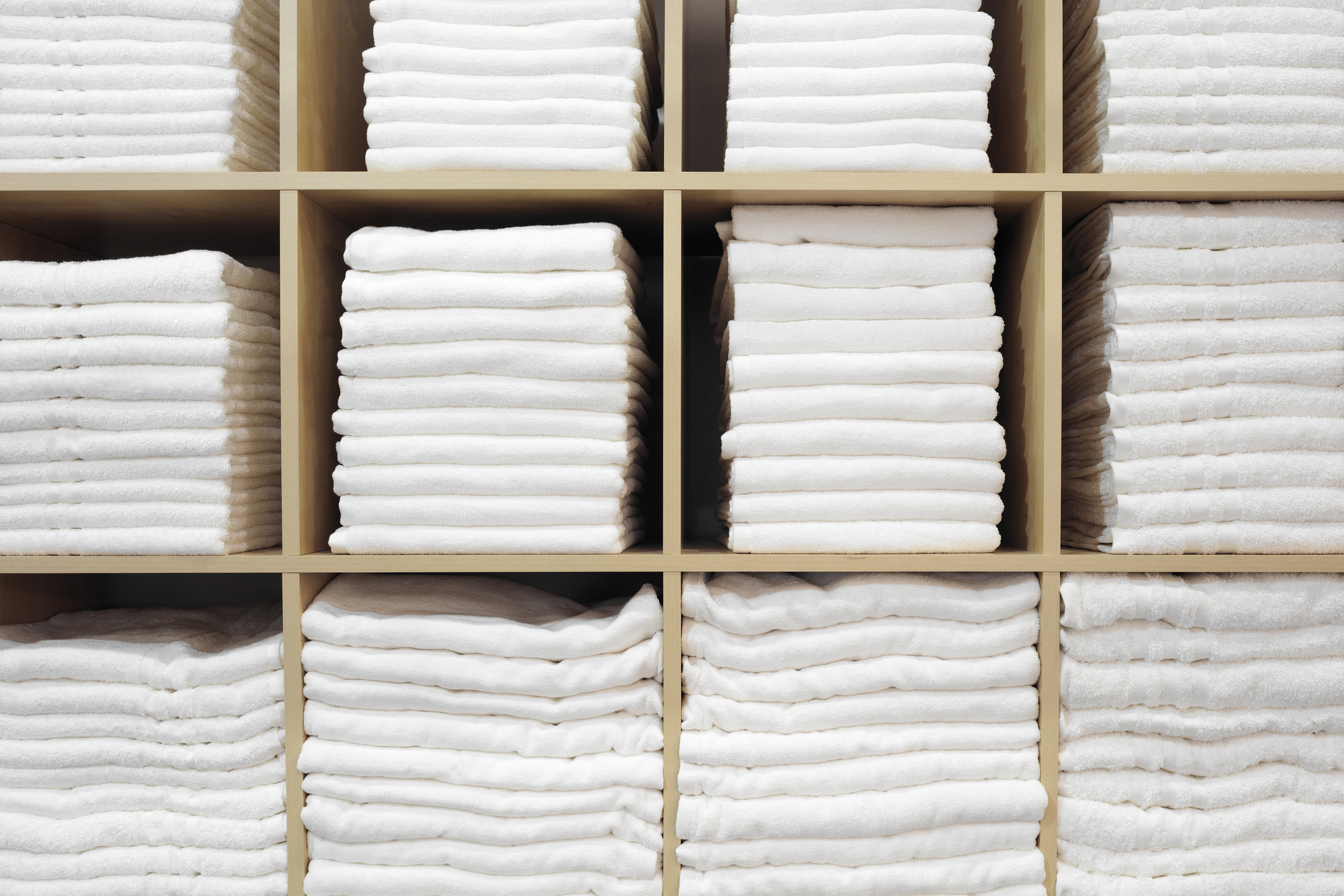 Organized linen closet with standardized white hospitality linens