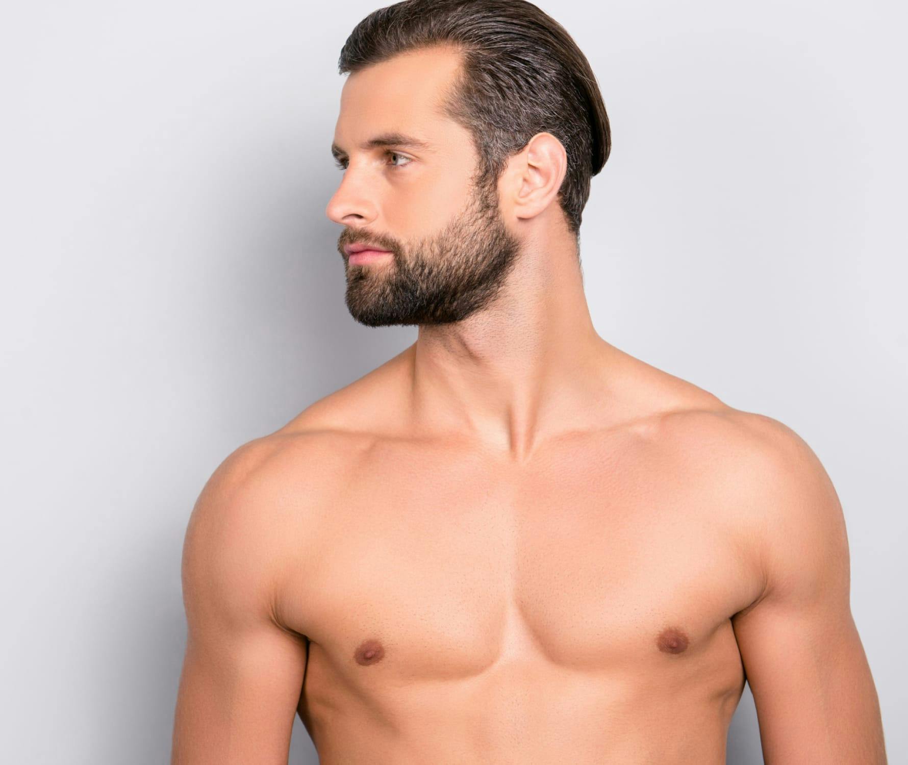Shirtless man posing against white background