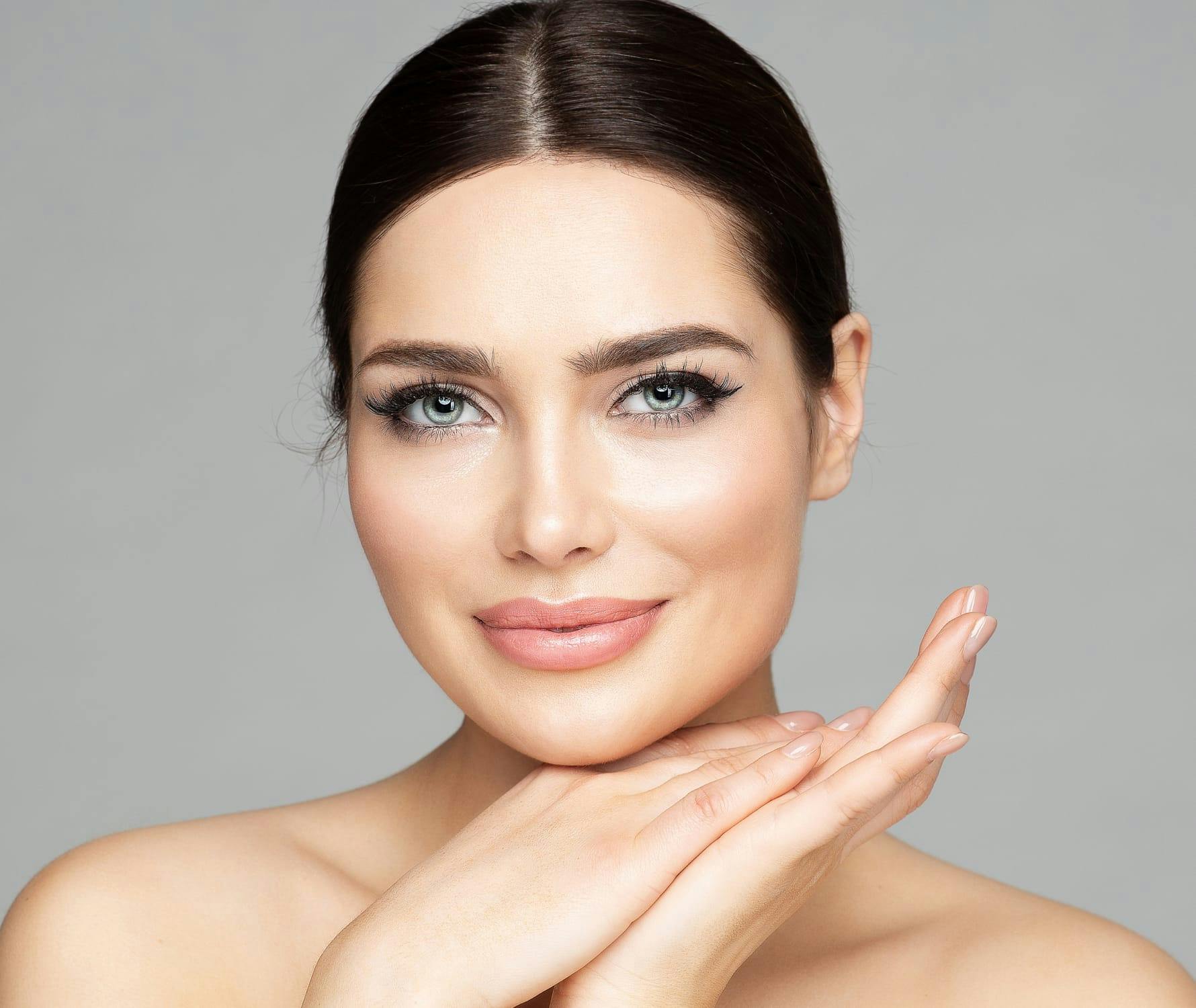 Woman smiling with hands on chin
