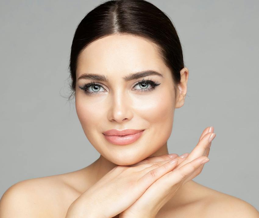Woman smiling with hands on chin