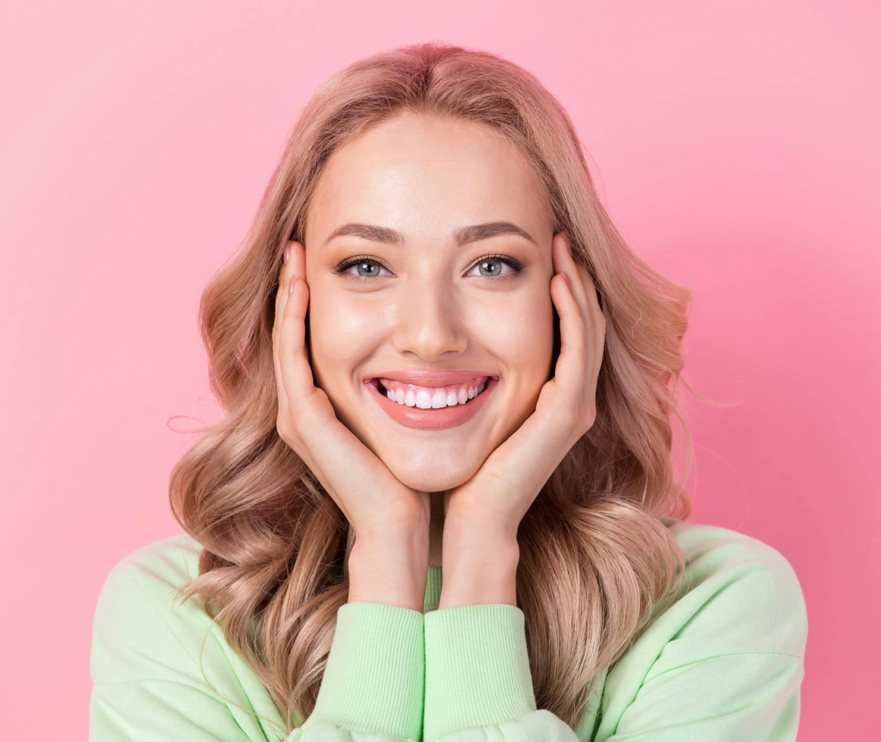 Woman smiling holding face