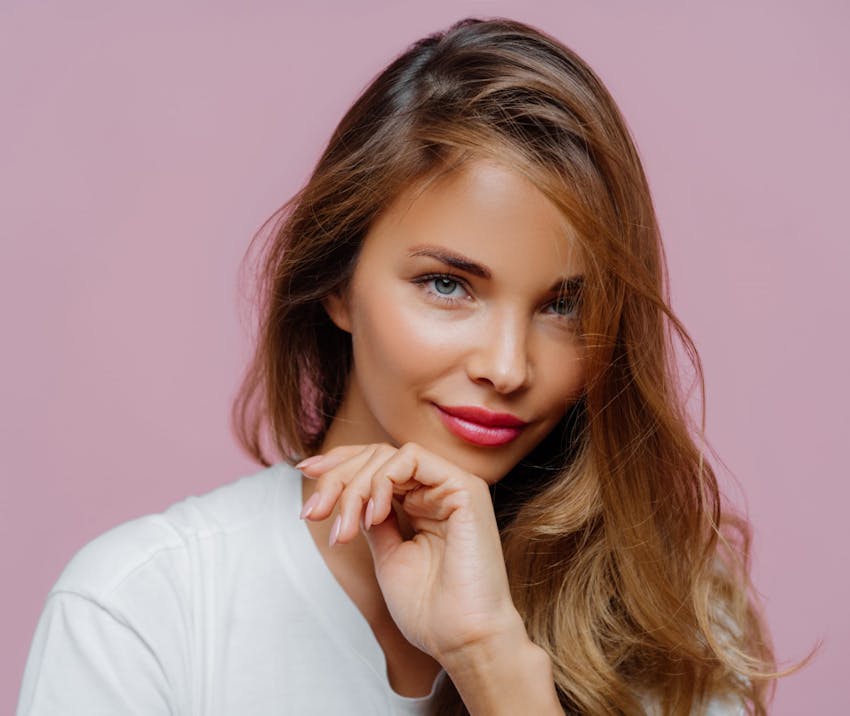 Woman smiling with hand near mouth