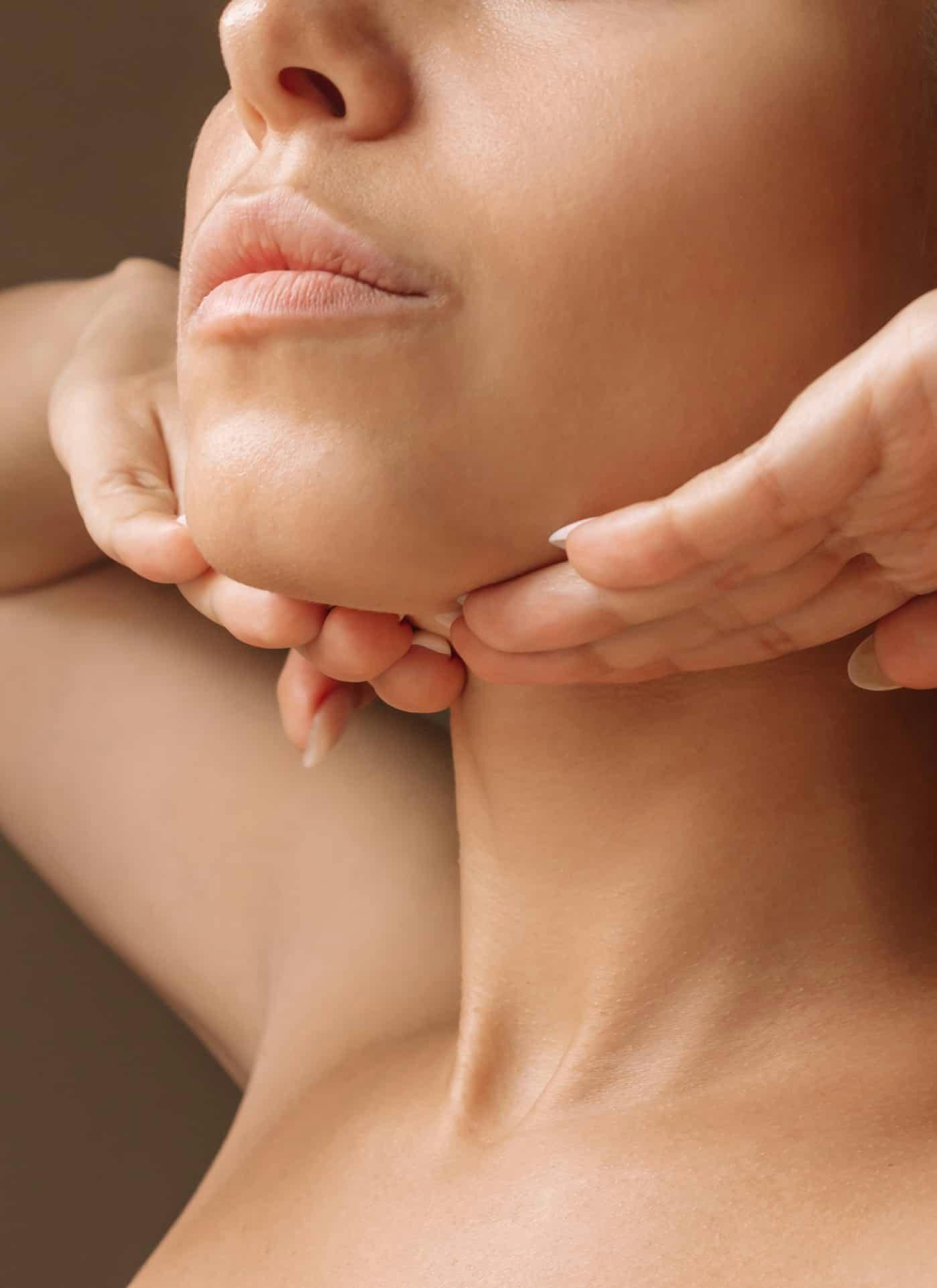 Woman touching chin and neck area