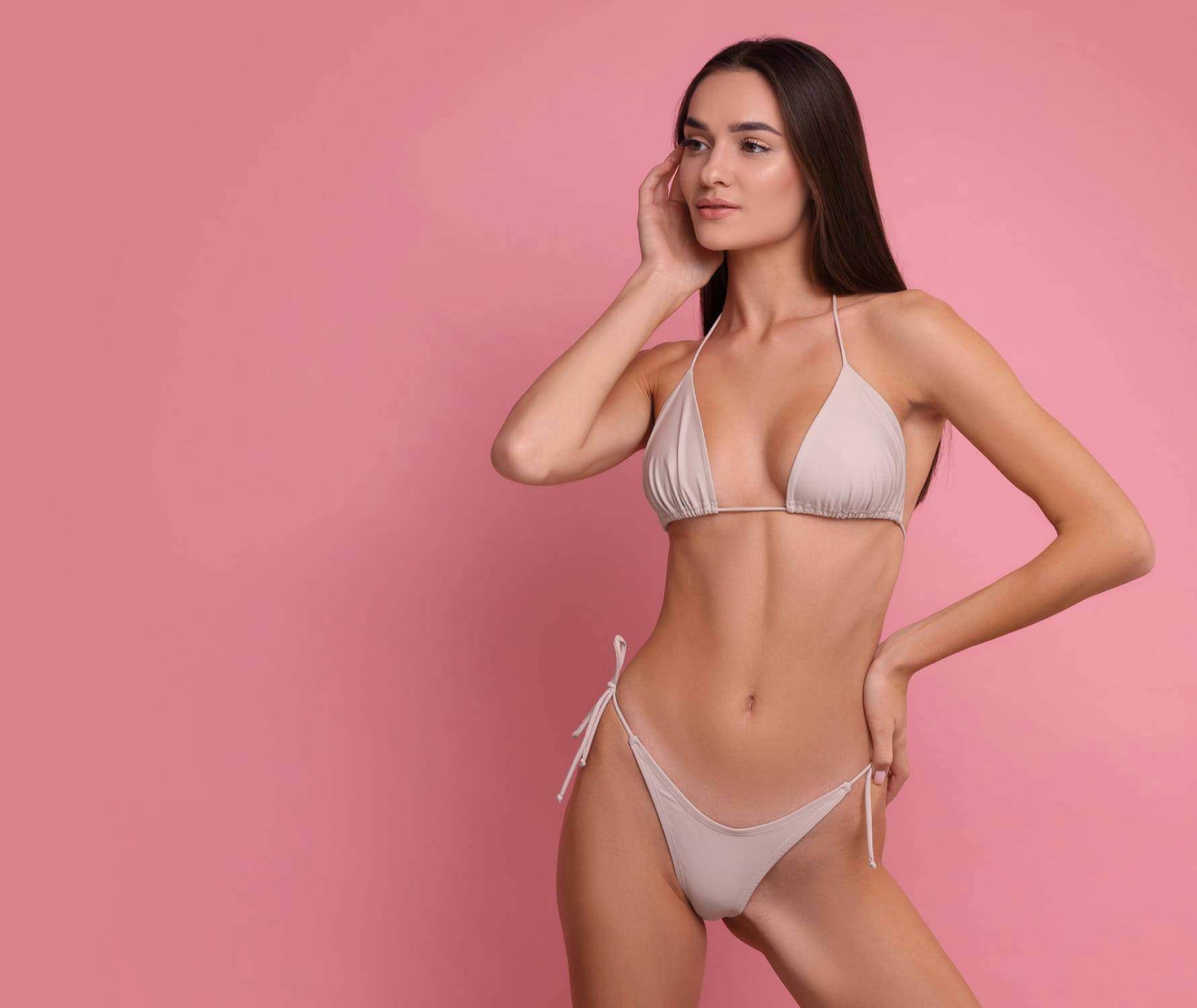woman in bikini touching her face