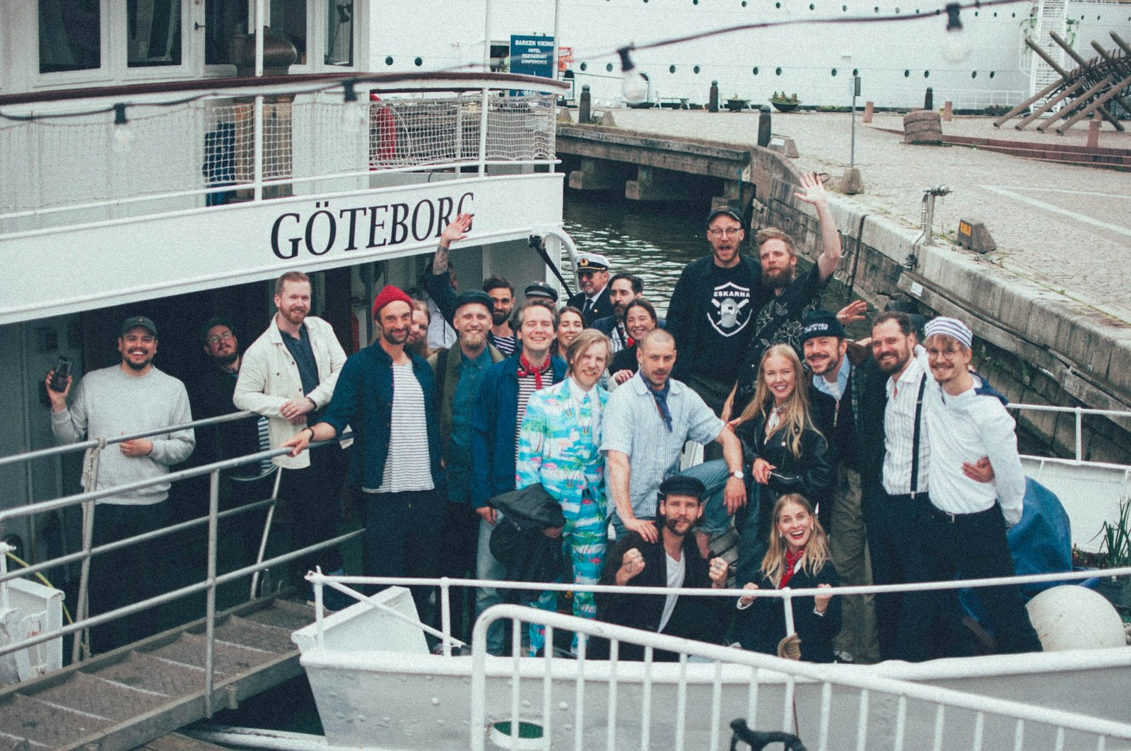 Group of people posing together on a boat, smiling and celebrating.