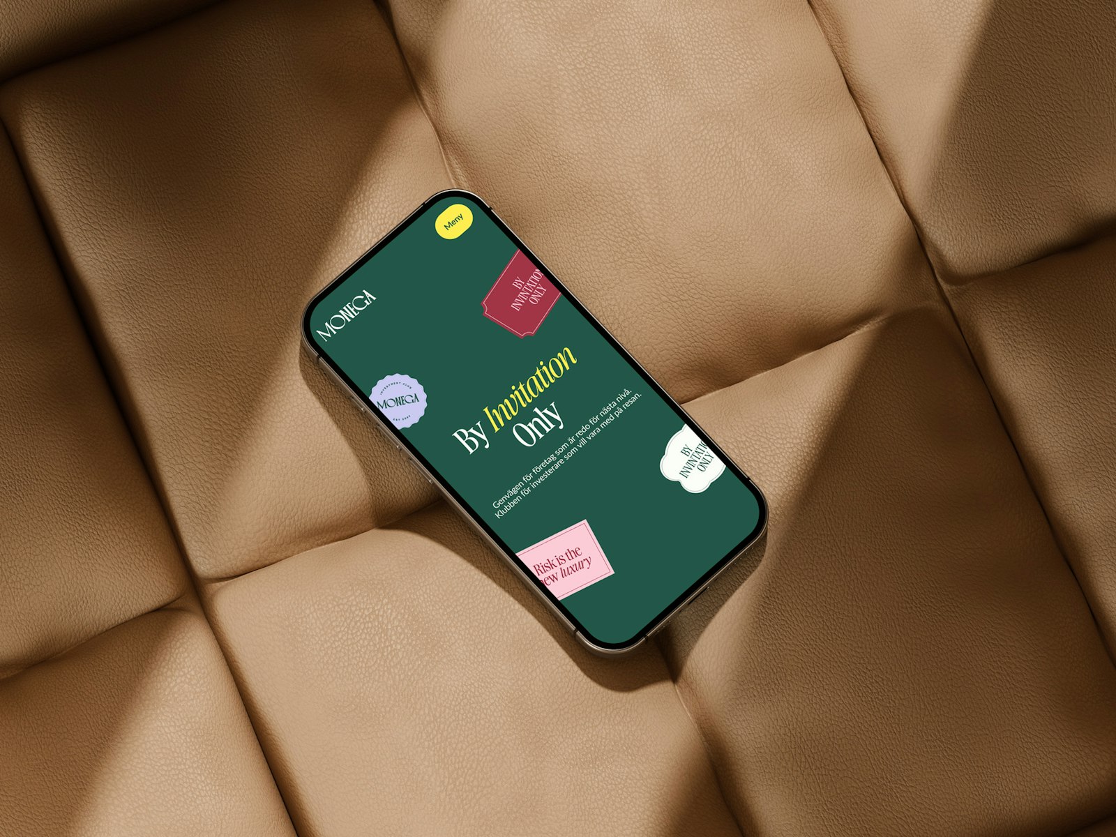 Phone showing Monega app on cushioned background.