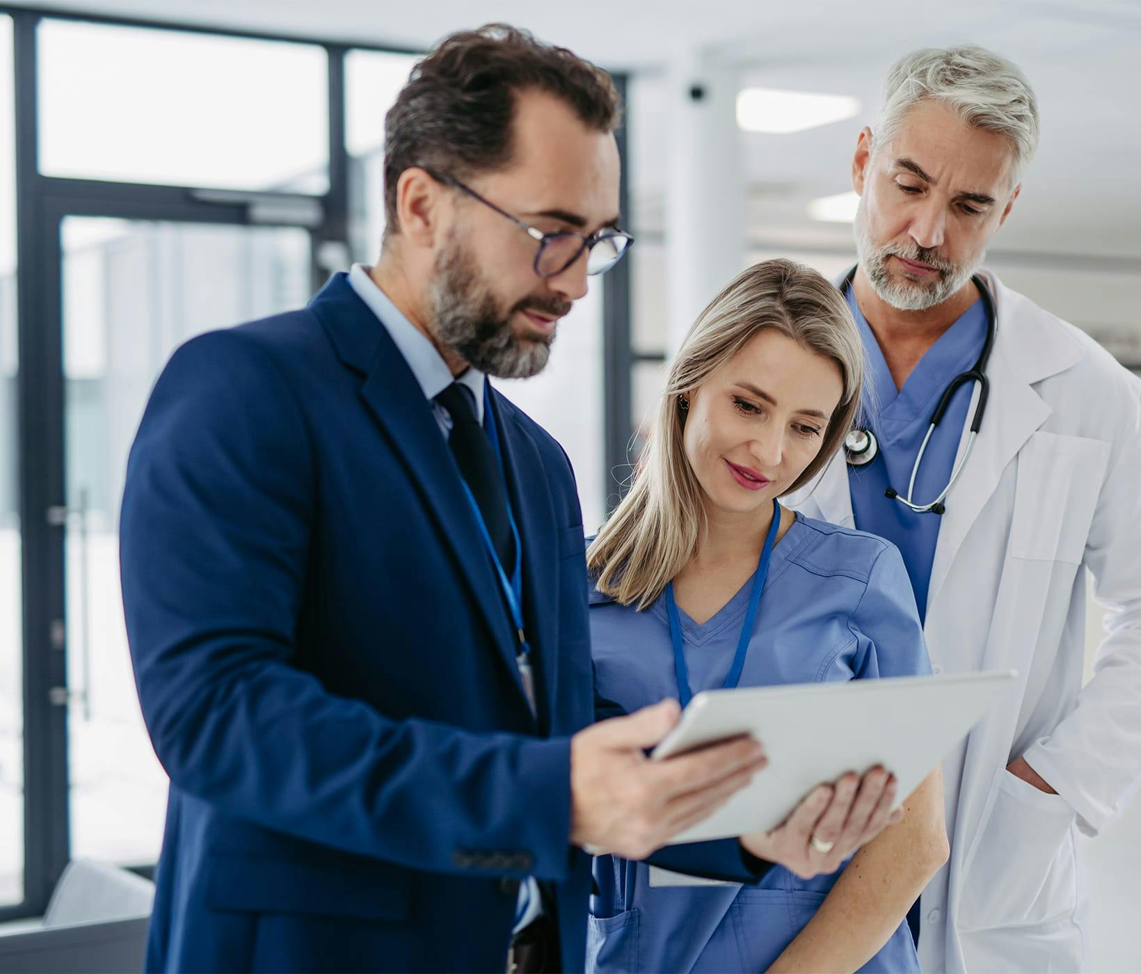 three doctors looking at a tablet
